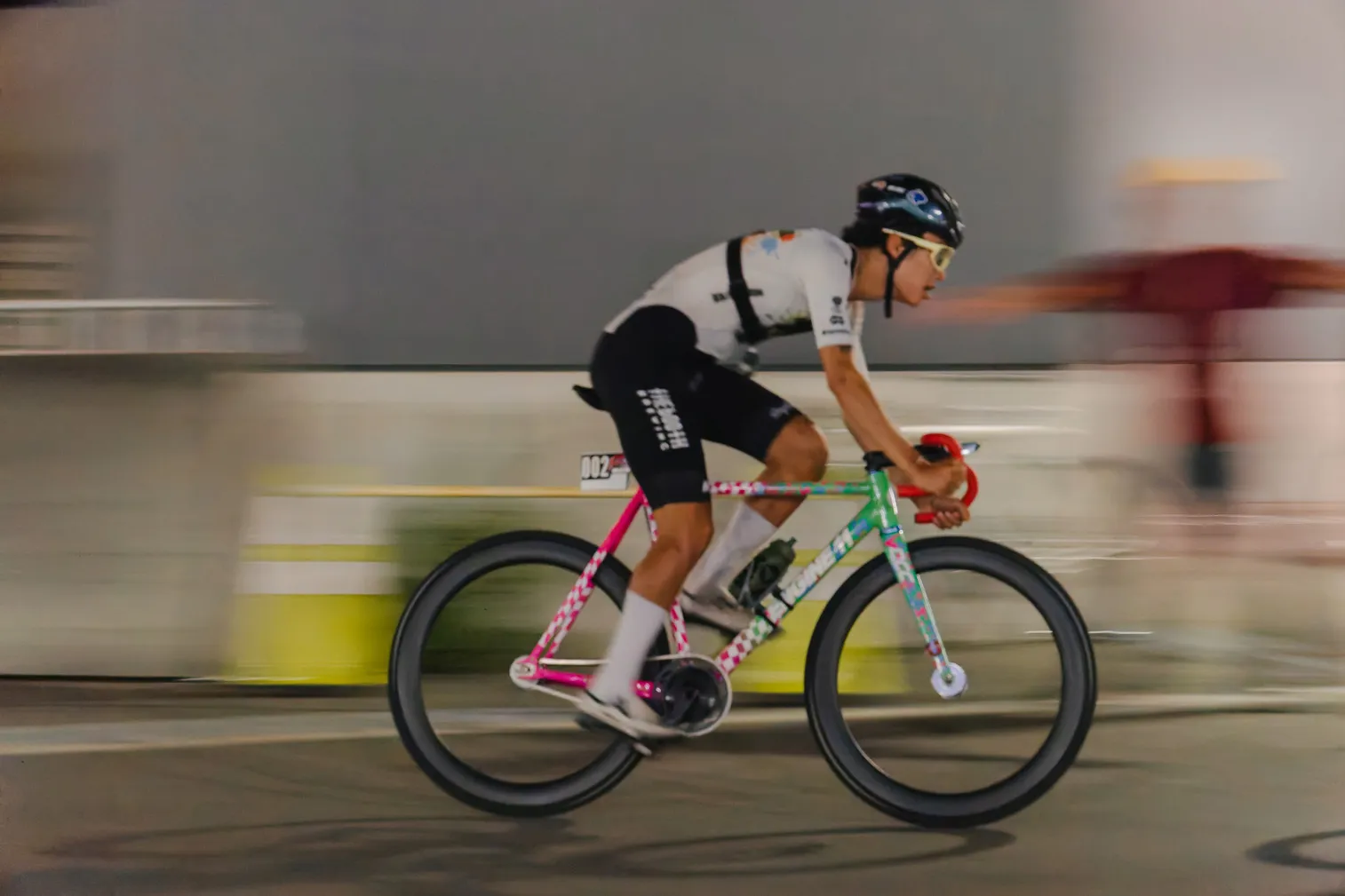 夜の道路で、自転車選手を流し撮りした写真
