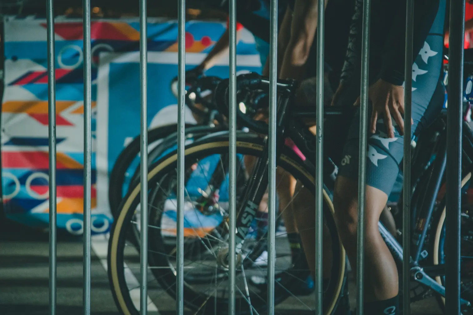 フェンスの向こうに自転車とカラフルな背景が見える写真